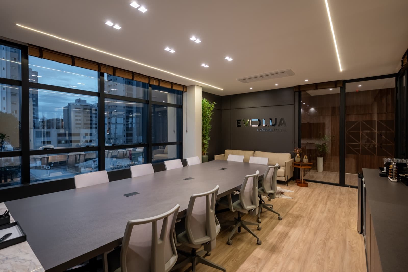 Sala de reunião da Evolua com mesa longa e parede de vidro com o logo